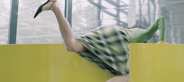 Businesswoman Awkwardly Bending over Yellow Counter